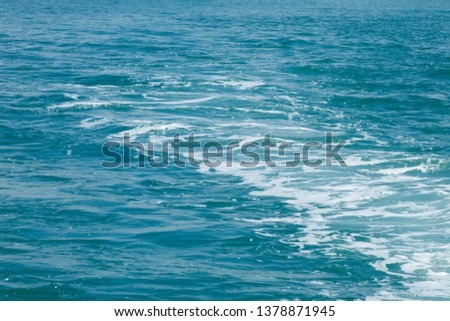 Blue wavy ocean background with an white foam