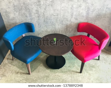 Blue and red chairs with wooden table, interior decoration for relax corner in the coffee shop.
