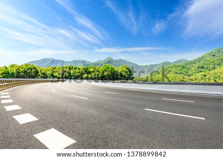 Country road and green mountains natural landscape under the blue sky