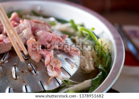 Thai barbecue grill pork on hot pan buffet, cooking barbecue pork fatty foods, Moo-Kra-Ta in Thai word Royalty-Free Stock Photo #1378951682