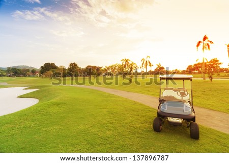 golf car with sun set in golf course. Royalty-Free Stock Photo #137896787