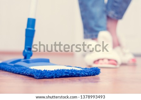 Woman washes the floor, flat wet-mop, cleaning her house, women's legs, close up, cropped image