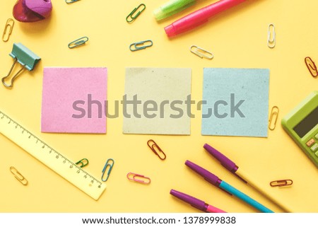 School office supplies.Creative desk with colourful stationery. Colored paper clip.School supplies on yellow background.Office desk.