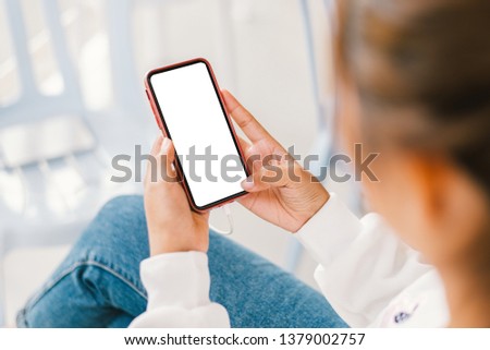 Young Asian woman using smartphone (white screen) at coffee shop. technology and bussiness concept background.  Royalty-Free Stock Photo #1379002757