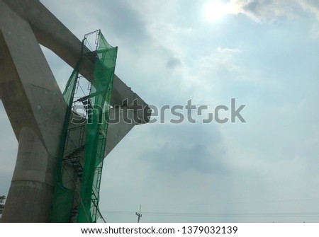 Big concrete post in the sun weather.large concrete post and scaffolding on sky background.