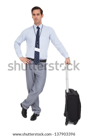 Serious businessman next to his suitcase on white background