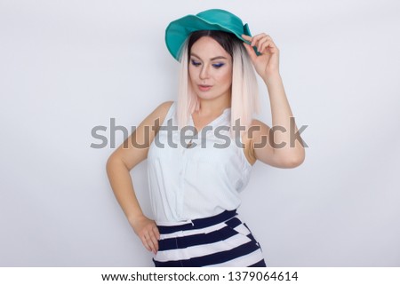 Image of beautiful excited emotional amazing young blonde woman with green hat, posing isolated over white background