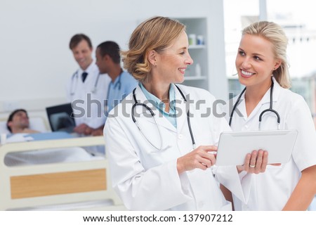 Smiling doctors talking to each other in hospital room Royalty-Free Stock Photo #137907212