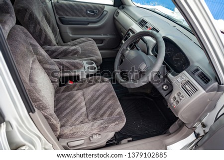 View to the gray color interior of suv car with front seats, steering wheel and dashboard  with striped fabric upholstery after cleaning and detailing in the vehicle repair workshop Royalty-Free Stock Photo #1379102885