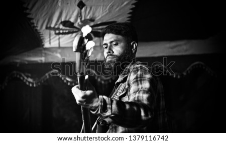 Bearded singer playing an electric guitar in a concert