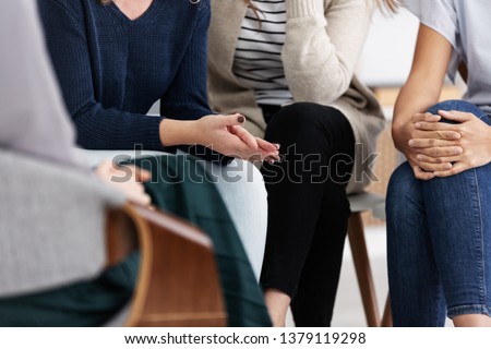 Anonymous women sitting in circle during group meeting Royalty-Free Stock Photo #1379119298