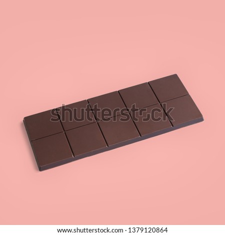 Chocolate bar on a pink background. Minimal concept Royalty-Free Stock Photo #1379120864