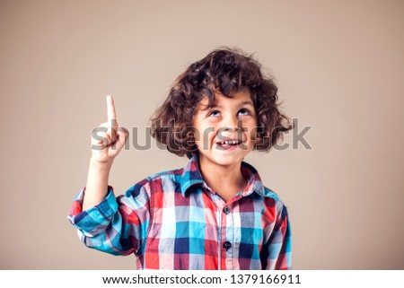 Portrait of cheerful boy with good idea - isolated over grey background