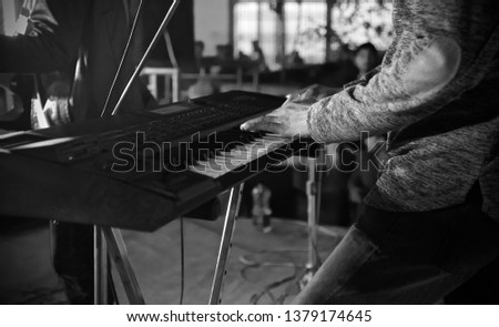 Man playing an electric piano by hands in a concert