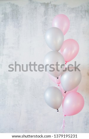 Bunch of pink and gray balloons for birthday party on gray concret background with copy space