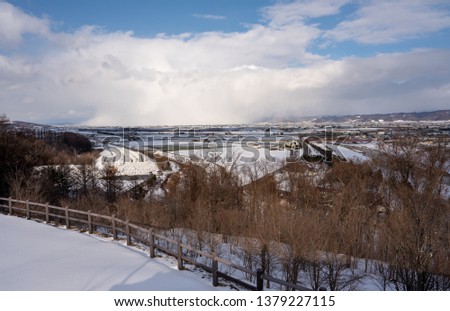 Snowing to the city with blue sky. This photo shoot from viewpoint at Furano winery hill, Japan.