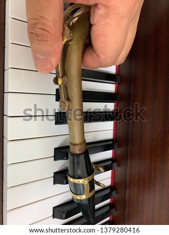 Saxophone neck on piano