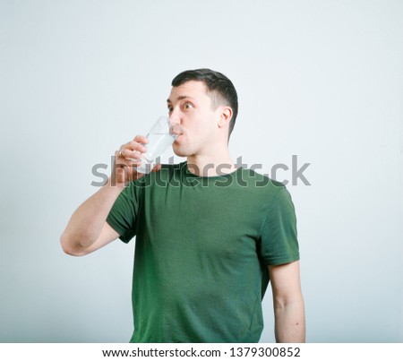 successful man drinking a glass of water, studio photo over background