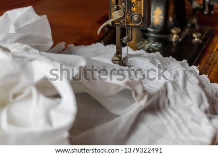 Process of sewing on the ancient sewing machine in the antiquarian case. Soft focus.