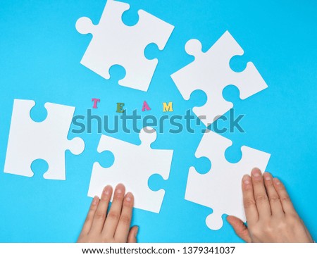 white big puzzles on a blue background,  inscription team,  concept of recruitment in the company