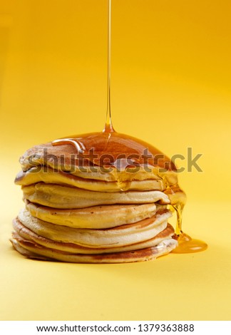 pancakes on a yellow background. poured with honey or syrup Royalty-Free Stock Photo #1379363888