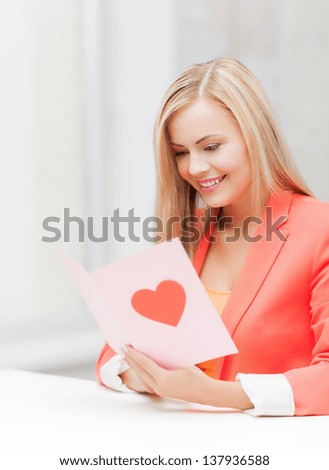picture of woman holding postcard with heart shape.