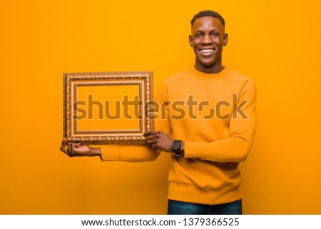 young black african american man with a baroque frame against orange background