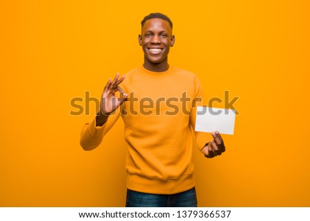 young black african american man with a placard against orange background