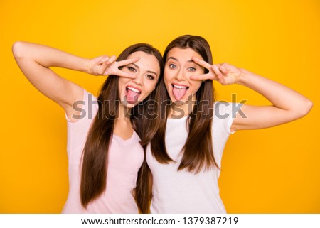 Like children. Close up photo satisfied enjoy teens best teenagers foolish girls students travel trip free time feel careless rejoice make v-signs long hair cotton t-shirts isolated yellow background