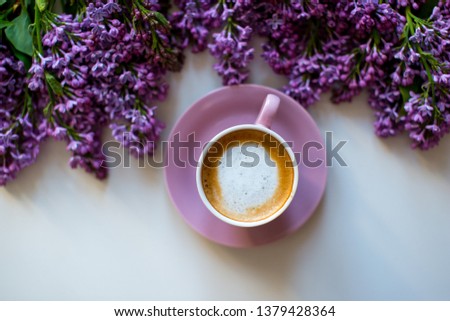 Floral composition made of beautiful purple lilac, syringa flowers on white background with cup of coffee. Feminine office desk, styled stock image, flat lay, top view with empty space. 