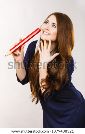 Student college girl looking elegant woman wearing dark dress holding big oversized pencil