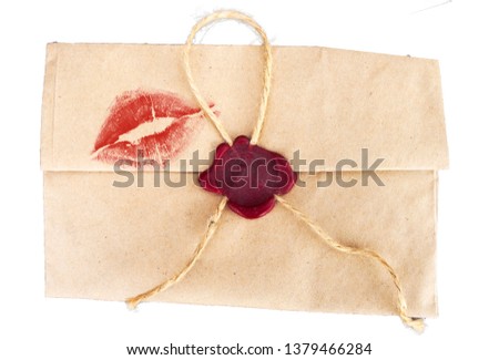 Ретро конверт на белом фоне со следом поцелуя и красной сургучной печатью.