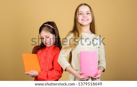 Sisters pick books to read together. Adorable girls love books. Secret diary or personal journal. Smart is great. Kids girls with books or notepads. Education and kids literature. Favorite fairytale.