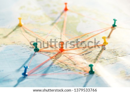 Selective focus of colorful push pins and strings on world map