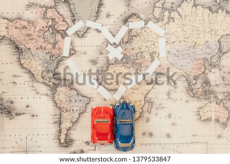 Top view of red and blue toy cars on world map