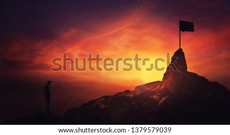 Self overcome concept, climber man hand to forehead looking attentive to horizon finding the finish flag. Road to achieve success over sunset sky background. Life quest obstacles, reaching goals. Royalty-Free Stock Photo #1379579039