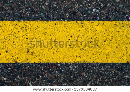 Road marking line with yellow paint on asphalt. Marking the motorway. Close-up