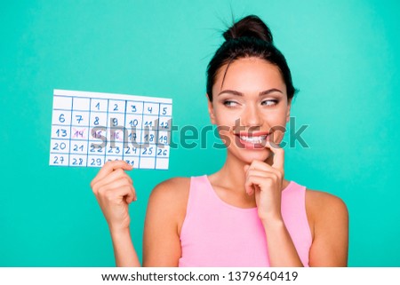 Close up photo beautiful amazing she her lady funny hairstyle bite finger hold hand arm paper calendar birthday party coming tricky mood wear casual pink tank-top isolated teal turquoise background