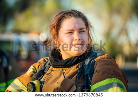 Female firefighter isolated in full bunker gear after a fire.  Royalty-Free Stock Photo #1379670845