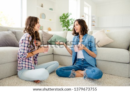 Close up photo beautiful she her ladies buddies fellows meeting hot beverage hands arms sharing news rumours wear casual jeans denim checkered plaid shirts apartments sit floor divan room indoors Royalty-Free Stock Photo #1379673755