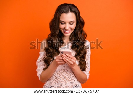 Portrait of her she nice-looking sweet attractive lovely winsome cheerful cheery wavy-haired lady in transparent blouse using app isolated over bright vivid shine orange background