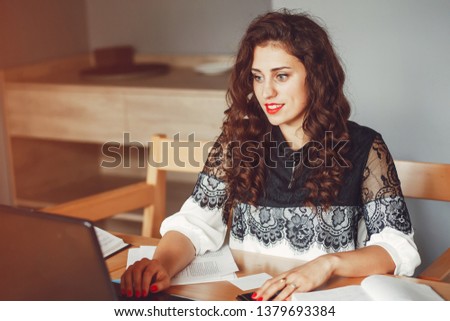 Beautiful girl in the office. Woman is working. A woman with curly hair
