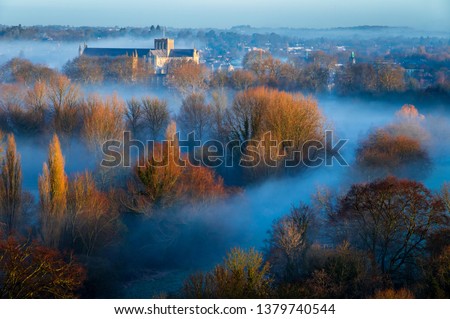 Early morning mist in February on St Catherine's hill on the Hampshire south downs south east England, with Winchester Cathedral rising above to catch the dawn sunlight.   Royalty-Free Stock Photo #1379740544