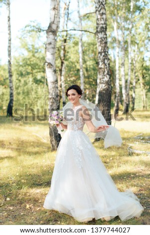 Beautiful girl in a white dress in a birch forest