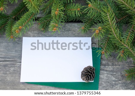 Green branches of a Christmas tree and cones on the background of old, wooden boards. Top view with copy space for your text.