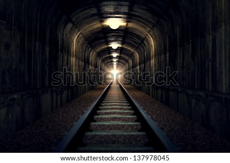 A railroad tunnel with a light at the end. Can represent achieving your goals, getting through problems and obstacles or simply represent exactly what you can see - an old tunnel. Royalty-Free Stock Photo #137978045