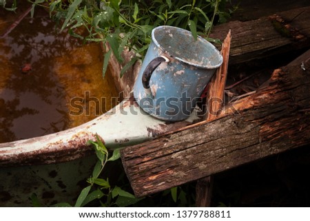 Rural farm. Mug for watering plants in the garden. Picture taken in Ukraine. Kiev region. Horizontal frame. Color image