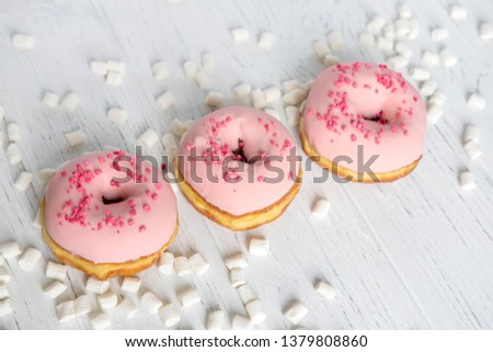 Banner with donuts on a wooden background. Photo of donuts and marshmallows on a wooden background.