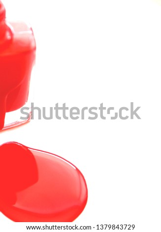 Bottle and stain of red nail Polish isolated on white background.