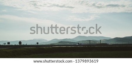 French Vosges mountains range with silhouette of car, trucks driving fast on the national autoroute highway with magestic scattered clouds sky